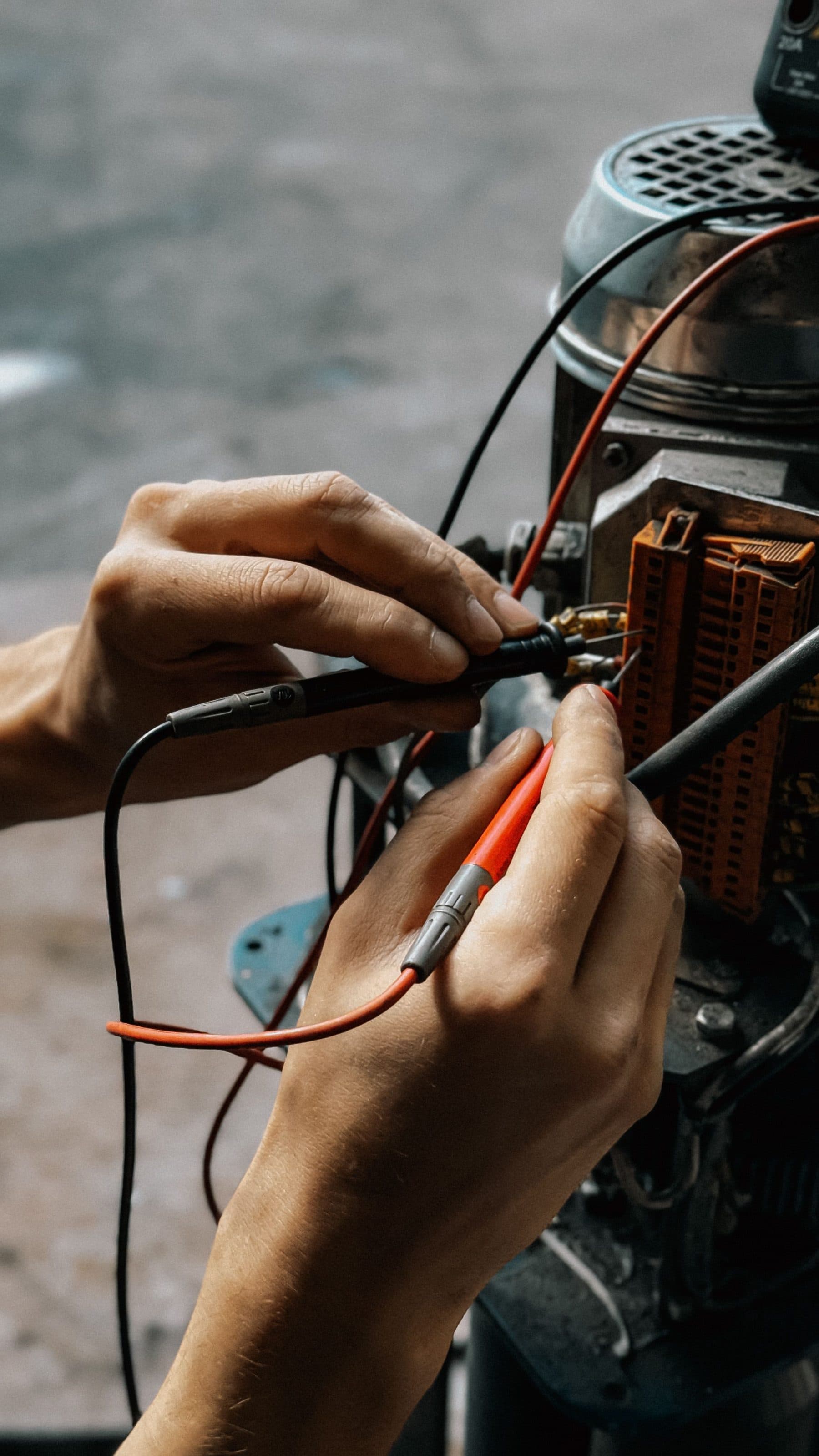Teknisyen elektrik motorunun bağlantı kutusunda ölçü uçlarıyla ölçüm yapıyor, yakın plan