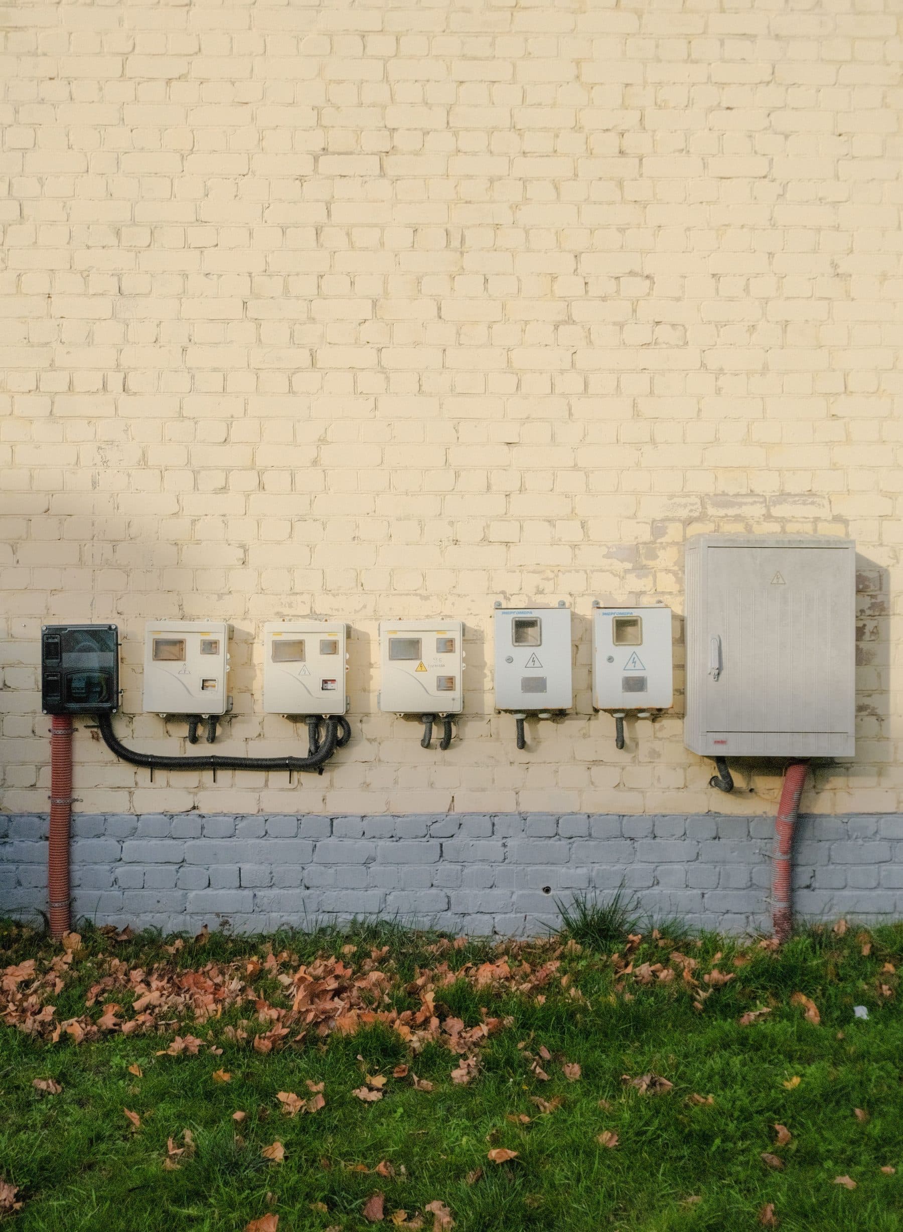 Tuğla duvara monte edilmiş sıra sıra elektrik sayacı kutuları